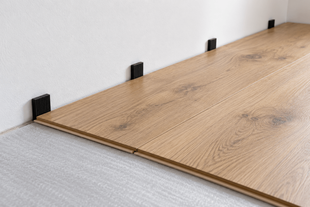 Cales de dilatation entre le plancher flottant et le mur